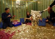 Committee members for the initiative "CHF 2,500 monthly for everyone" (Grundeinkommen) open rolls of five cent coins in the old vault of the former Schweizerische Volksbank in Basel October 1, 2013. The committee dumped 8,000,000 five cent coins, weighting 15 tones, over the Federal Square in Bern on Friday, before delivering 126,000 signatures to the Chancellery to propose a change in the constitution to implement their initiative. The initiative aims to have a minimum monthly disposal household income of CHF 2,500 (US$ 2,700) given by the government to every citizen living in Switzerland. Picture taken October 1, 2013. REUTERS/Ruben Sprich (SWITZERLAND - Tags: POLITICS CIVIL UNREST)