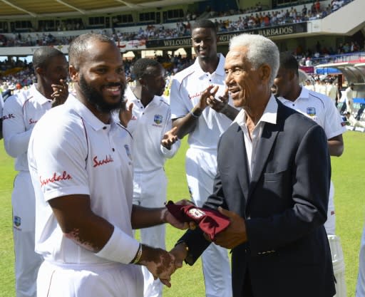 Past and present: Garfield Sobers (R), presents debutant John Campbell (L) with his cap before the start of the first Test against England in Barbados as West Indies captain Jason Holder (3R) looks on