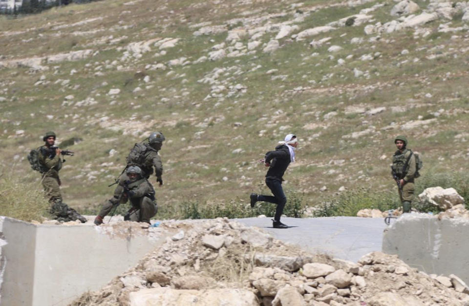 In this Thursday, Apri 18, 2019 photo, handcuffed and blindfolded Osama Hajahjeh, 16, runs away from Israeli soldiers near the village of Tekoa, West Bank. Hajahjeh said was shot in his legs last week by Israeli soldiers while he was handcuffed and blindfolded, shortly after being arrested. The military said it was investigating the incident, which it said occurred as Palestinian youths were throwing stones at Israeli soldiers. (AP Photo/Mohammad Hmeid)