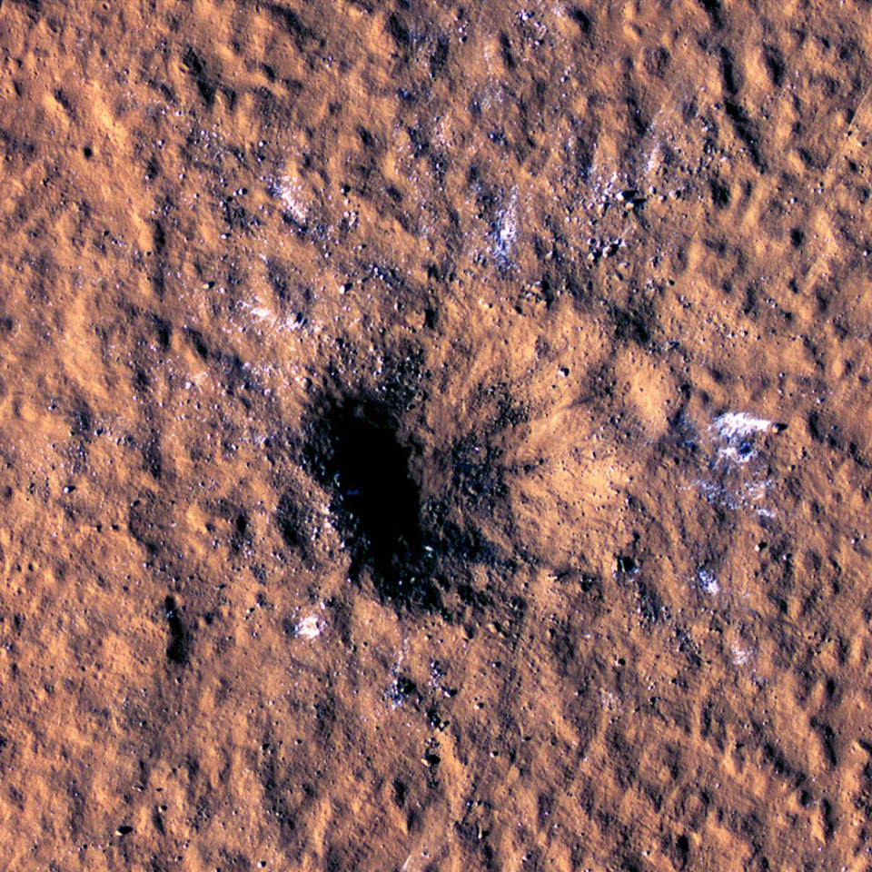 In this image made available by NASA on Thursday, Oct. 27, 2022, boulder-size blocks of water ice are seen around the rim of an impact crater on Mars, as viewed by the High-Resolution Imaging Science Experiment (HiRISE camera) aboard NASA's Mars Reconnaissance Orbiter. The crater was formed Dec. 24, 2021, by a meteoroid strike in the Amazonis Planitia region. (NASA/JPL-Caltech/University of Arizona via AP)