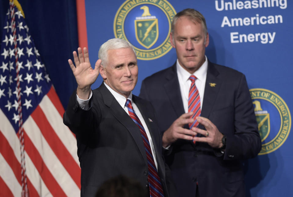 FILE - In this June 29, 2017, file photo, Vice President Mike Pence, left, waves as he is introduced to speak at the Department of Energy in Washington, as Interior Secretary Ryan Zinke watches. As former U.S. Interior Secretary Zinke exits Washington amid a cloud of unresolved ethics investigations, he says he has lived up to the conservation ideals of Teddy Roosevelt and insists the myriad allegations against him will be proven untrue. Zinke said he quit President Donald Trump’s cabinet on his own terms, despite indications he was pressured by the White House to resign effective Wednesday, Jan. 2, 2019. (AP Photo/Susan Walsh, File)