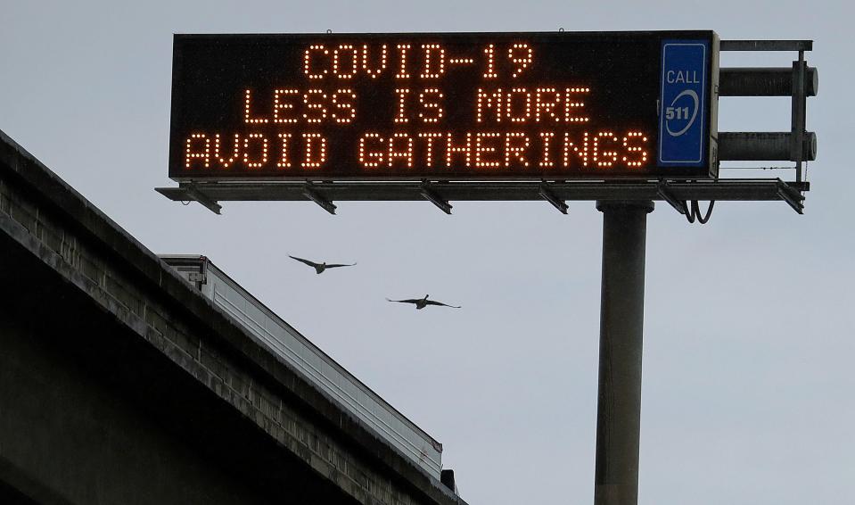 A COVID-19 warning sign is displayed along westbound Interstate-880, Saturday, March 14, 2020, in San Leandro, Calif. The California Department of Transportation is displaying public health messages concerning the coronavirus on the state's more than 700 electric signs. (AP Photo/Ben Margot)