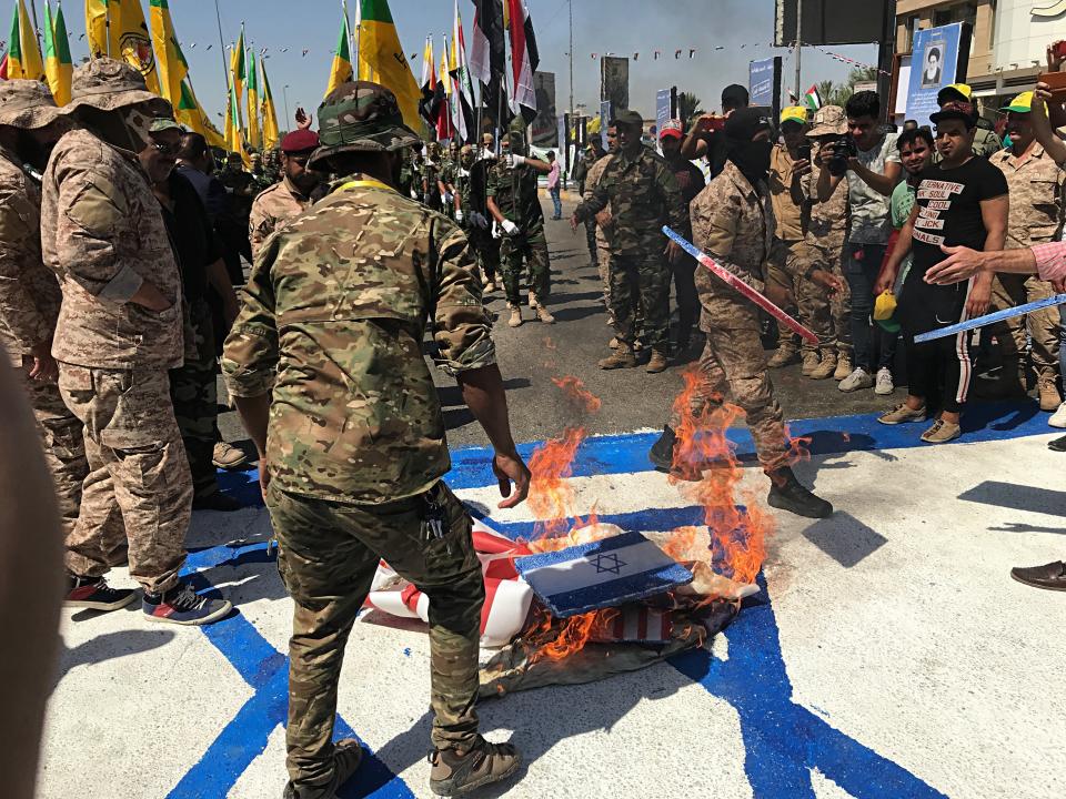 Iraqi Popular Mobilization Forces burn representations of U.S. and Israeli flags during "al-Quds" Day, Arabic for Jerusalem, in Baghdad, Iraq, Friday, May 31, 2019. Jerusalem Day began after the 1979 Islamic Revolution in Iran when the Ayatollah Khomeini declared the last Friday of the Muslim holy month of Ramadan a day to demonstrate the importance of Jerusalem to Muslims. (AP Photo/Ali Abdul Hassan)