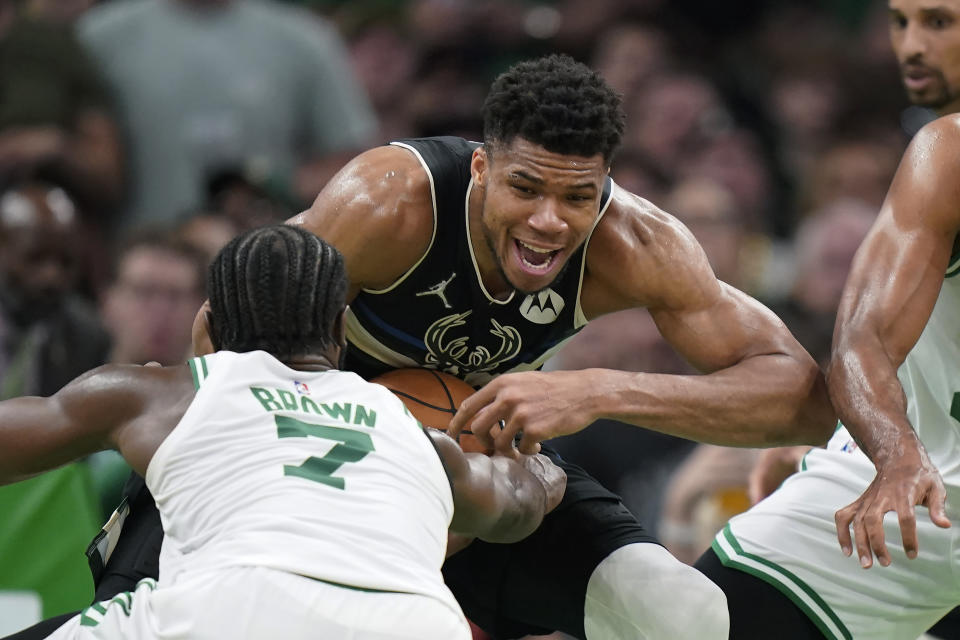 Milwaukee Bucks forward Giannis Antetokounmpo, center, grapples with Boston Celtics guard Jaylen Brown (7) during the second half of Game 7 of an NBA basketball Eastern Conference semifinals playoff series, Sunday, May 15, 2022, in Boston. (AP Photo/Steven Senne)