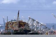 FILE - The collapsed Francis Scott Key Bridge rests on the container ship Dali, May 12, 2024, in Baltimore, as seen from Riviera Beach, Md. The main shipping channel into Baltimore's port has fully reopened to its original depth and width following the March 26 collapse of the Francis Scott Key Bridge, according to officials Monday, June 10, 2024. (AP Photo/Mark Schiefelbein, File)