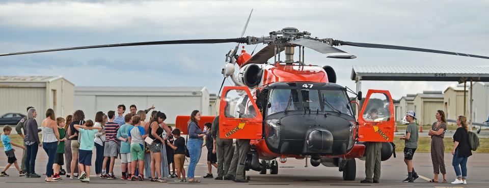 Students and moms line up to see the United States Coast Guard's MH-60 Jayhawk helicopter.