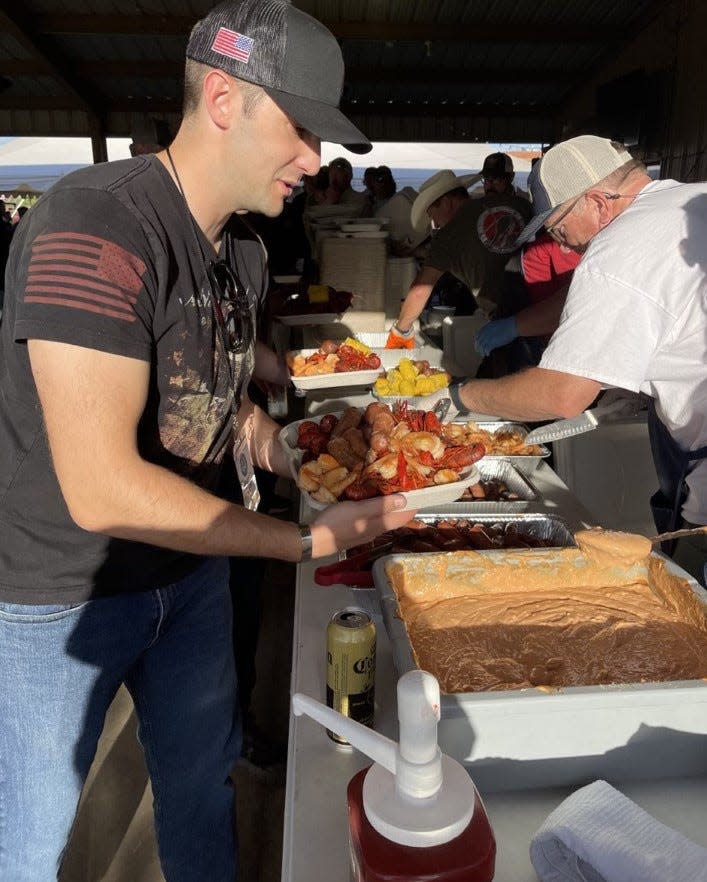 Max Wienke Sheppard Air Force Base volunteer loads up a plate with crawfish and sides at the Circle Bar Ranch Friday night during the helicopter hog hunt weekend.