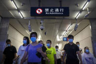 Commuters walk through a subway station during the morning rush hour in the central business district in Beijing, Tuesday, Aug. 9, 2022. China's 11 million university graduates are struggling in a bleak job market this summer as repeated shutdowns under China's anti-COVID lockdowns forced companies to retrench and driven many restaurants and other small employers out of business. (AP Photo/Mark Schiefelbein)