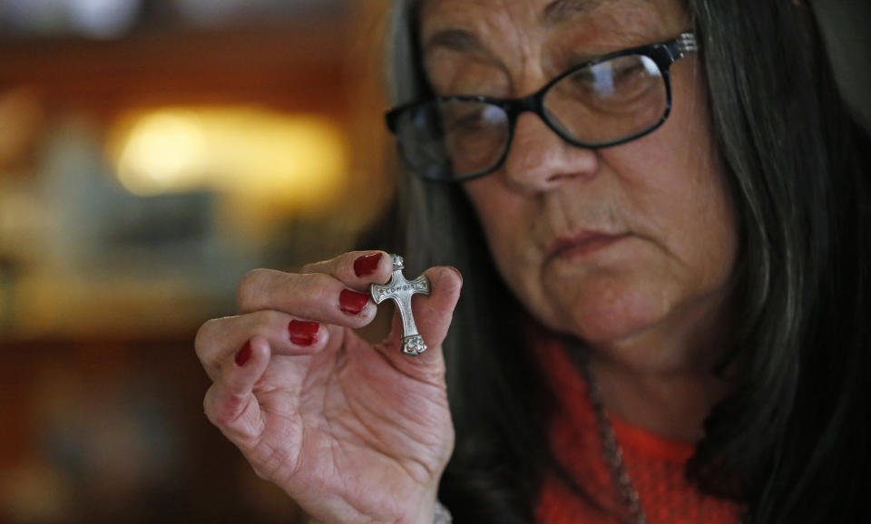 Melany Zoumadakis holds a crucifix while talking about her daughter, Tanna Jo Fillmore, at her home on Wednesday, April 24, 2019, in Salt Lake City. Fillmore, who had a history of mental problems, killed herself in 2016 at the Duchesne County Jail in Utah. Her mother, who has filed a lawsuit, says her daughter was denied her prescription medications and had threatened to harm herself when they spoke the day before her death. (AP Photo/Rick Bowmer)