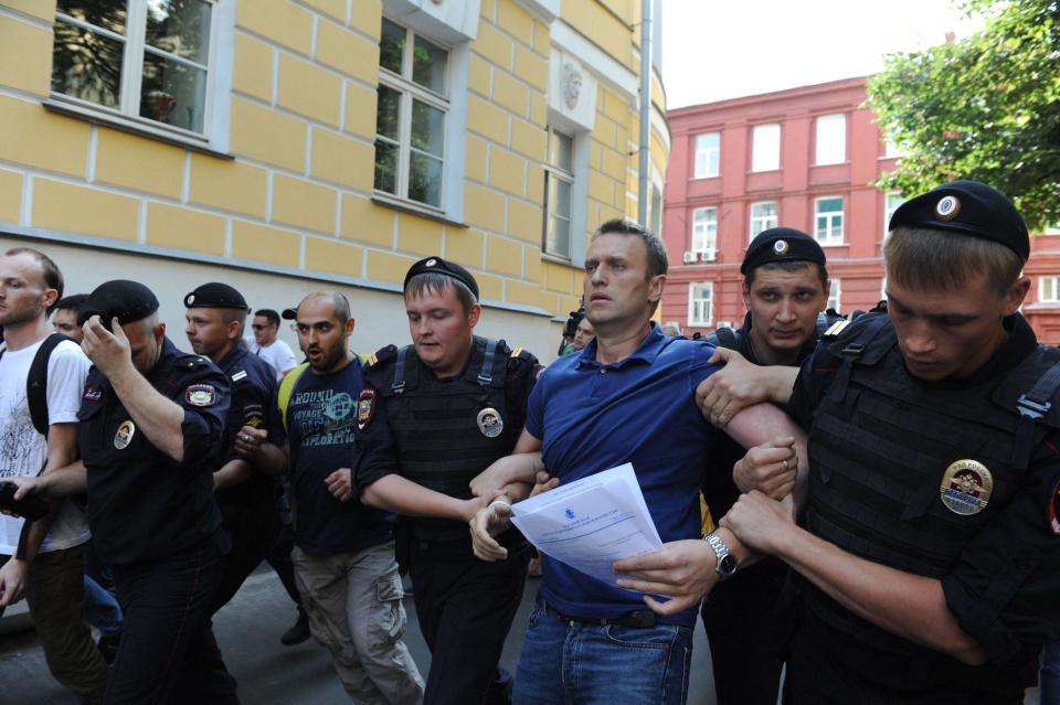 Police officers detain Alexei Navalny after his visit to the city's election commission office.