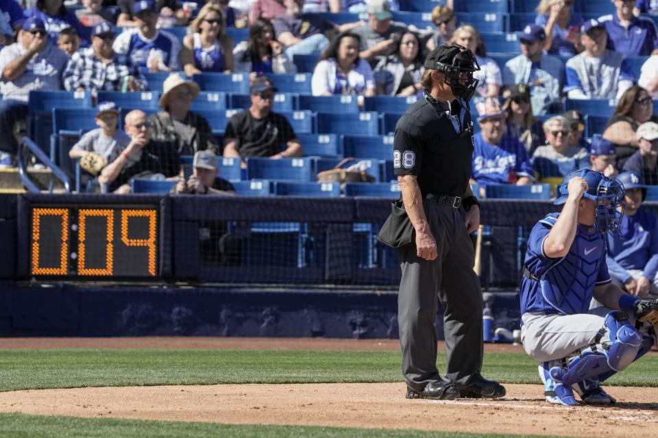 Home plate umpire Jim Wolf waits as the pitch clock counts down during the first inning.