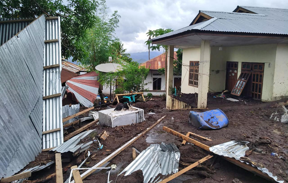 A dog sits amid the wreckage of buildings damaged by flooding on Adonara Island, East Flores, Indonesia, Monday, April 5, 2021. Multiple disasters caused by torrential rains in eastern Indonesia and neighboring East Timor have left a number of people dead or missing as rescuers were hampered by damaged bridges and roads and a lack of heavy equipment Monday. (AP Photo/Rofinus Monteiro)