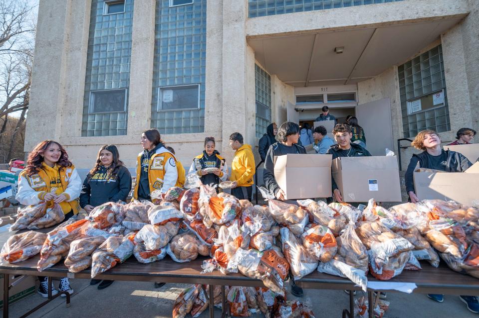 Local high school students stock boxes and help deliver them during the Tom and Louie's Cupboard food drive at St. Joseph's Hall on Saturday, November 18, 2023.