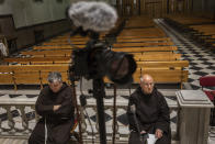 Catholic priests wait for the start of a Palm Sunday live video streamed mass inside the Jesus de Medinaceli church in Madrid, Spain, Sunday, April 5, 2020. Pilgrims were not allowed to attend the mass due to social distancing guidelines during the coronavirus outbreak. The new coronavirus causes mild or moderate symptoms for most people, but for some, especially older adults and people with existing health problems, it can cause more severe illness or death. (AP Photo/Bernat Armangue)