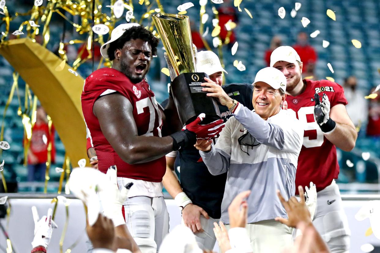 Alabama coach Nick Saban and offensive lineman Alex Leatherwood celebrate with the national championship trophy after beating Ohio State, Jan. 11, 2021. Saban has won seven national titles as a head coach.