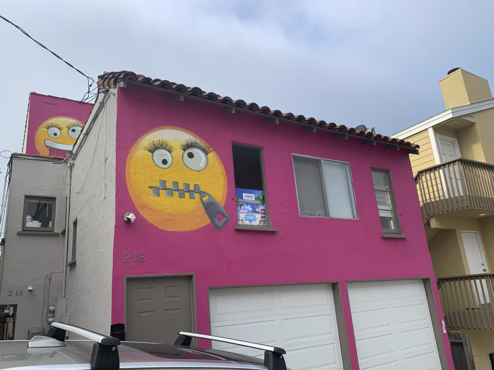 Painted emoji are seen on a house in Manhattan Beach, Calif. on Wednesday, Aug. 7, 2019. The Southern California seaside community is in an uproar after the home was given the new paint job featuring two huge emojis on a bright pink background. Manhattan Beach residents railed against the makeover during a City Council meeting Tuesday night, citing problems with spectators. (AP Photo/Natalie Rice)