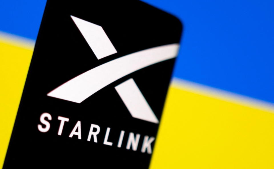 Starlink logo is seen on a smartphone in front of displayed Ukrainian flag in this illustration taken February 27, 2022. REUTERS/Dado Ruvic/Illustration
