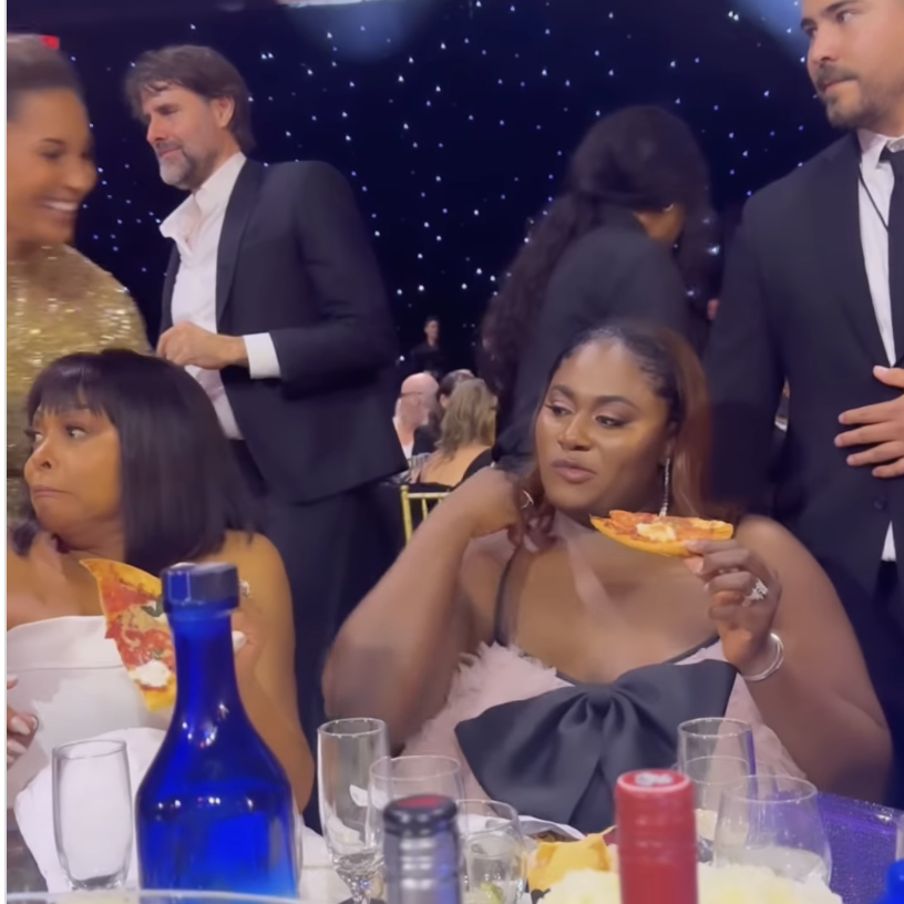 Taraji P. Henson and Danielle Brooks enjoying pizza while seated at a table with other attendees