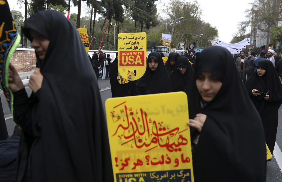 Demonstrators hold anti-U.S. placards in Arabic reading; during an annual rally in front of the former U.S. Embassy in Tehran, Iran, Monday, Nov. 4, 2019. Reviving decades-old cries of "Death to America," Iran on Monday marked the 40th anniversary of the 1979 student takeover of the U.S. Embassy in Tehran and the 444-day hostage crisis that followed as tensions remain high over the country's collapsing nuclear deal with world powers. The Arabic in top reads: “We shall never accept humiliation.” (AP Photo/Vahid Salemi)