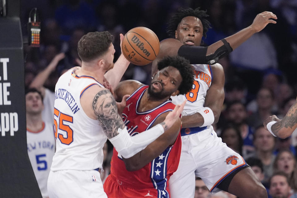 Philadelphia 76ers center Joel Embiid, center, fights for a rebound against New York Knicks center Isaiah Hartenstein (55) and forward OG Anunoby (8) during the first half in Game 1 of an NBA basketball first-round playoff series, Saturday, April 20, 2024, at Madison Square Garden in New York. (AP Photo/Mary Altaffer)