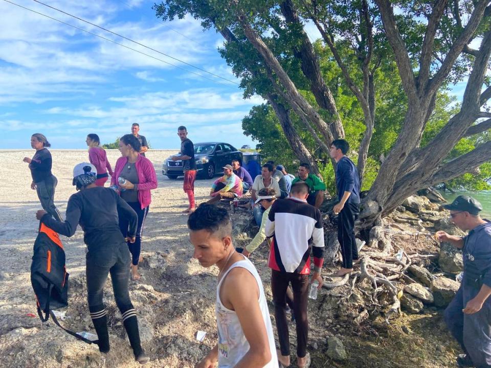 A group of people who just arrived on migrant boats from Cuba stand on the side of the road on Duck Key in the Florida Keys Monday, Jan. 2, 2023.