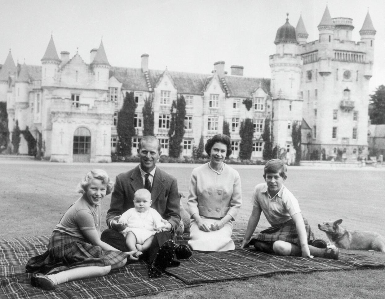 Queen Elizabeth II and Prince Philip, Duke of Edinburgh with their children, Prince Andrew (centre), Princess Anne (left) and Charles, Prince of Wales sitting on a picnic rug outside Balmoral Castle in Scotland, 8th September 1960.