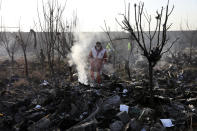 Rescue workers search the scene where an Ukrainian plane crashed in Shahedshahr, southwest of the capital Tehran, Iran, Wednesday, Jan. 8, 2020. A Ukrainian airplane carrying 176 people crashed on Wednesday shortly after takeoff from Tehran's main airport, killing all onboard. (AP Photo/Ebrahim Noroozi)