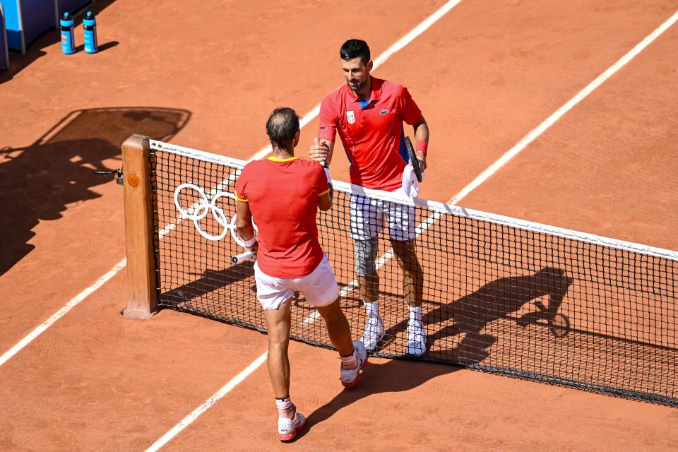 Rafael Nadal and Novak Djokovic embrace.