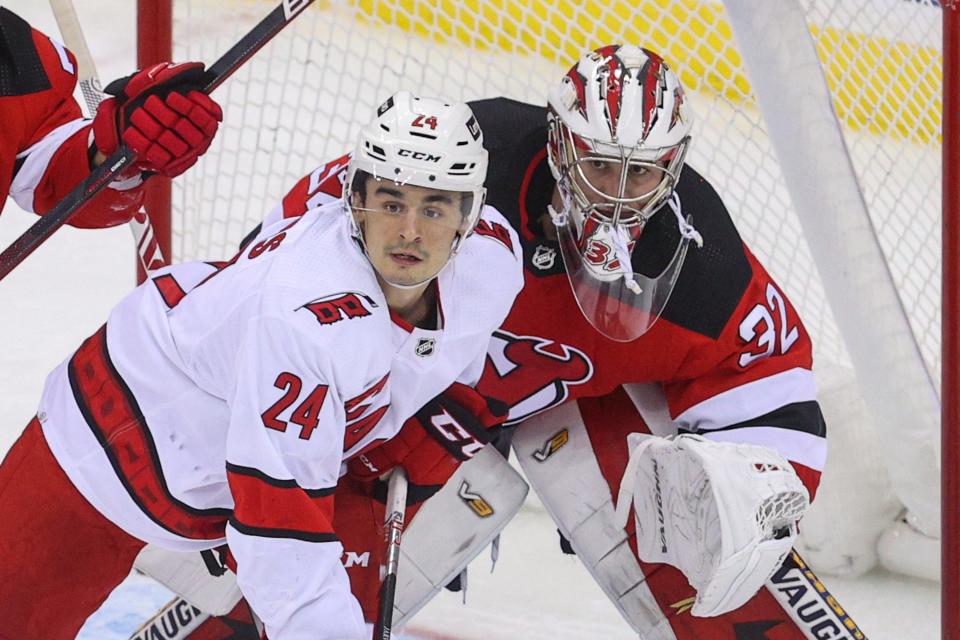 Jan 22, 2022; Newark, New Jersey, USA; New Jersey Devils goaltender Jon Gillies (32) looks around a screen by Carolina Hurricanes center Seth Jarvis (24) during the third period at Prudential Center. Mandatory Credit: Ed Mulholland-USA TODAY Sports