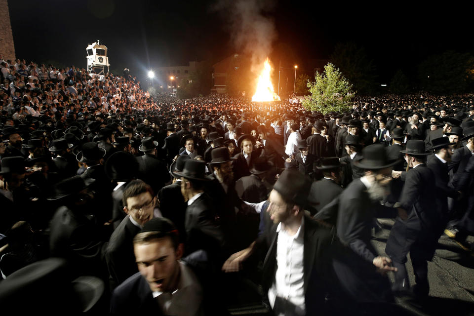 <p>Orthodox Jews of the Satmar Hasidim dance near a bonfire as they celebrate the Jewish holiday of Lag Ba’Omer, which marks the anniversary of the death of Talmudic sage Rabbi Shimon Bar Yochai approximately 1,900 years ago, in the village of Kiryas Joel, New York, U.S., May 25, 2016. (Mike Segar/REUTERS) </p>