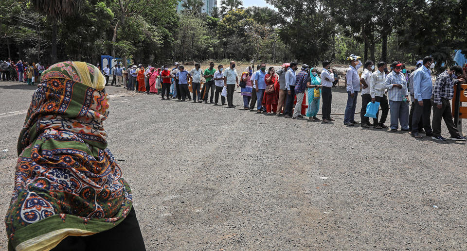 People queue as they wait to receive a shot of COVID-19 vaccine at a vaccination centre in Mumbai, India.