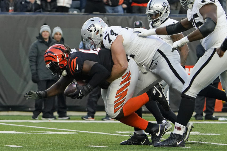 Cincinnati Bengals' Larry Ogunjobi (65) is tackled by Las Vegas Raiders' Kolton Miller after Ogunjobi recovered a fumble during the first half of an NFL wild-card playoff football game, Saturday, Jan. 15, 2022, in Cincinnati. (AP Photo/Jeff Dean)