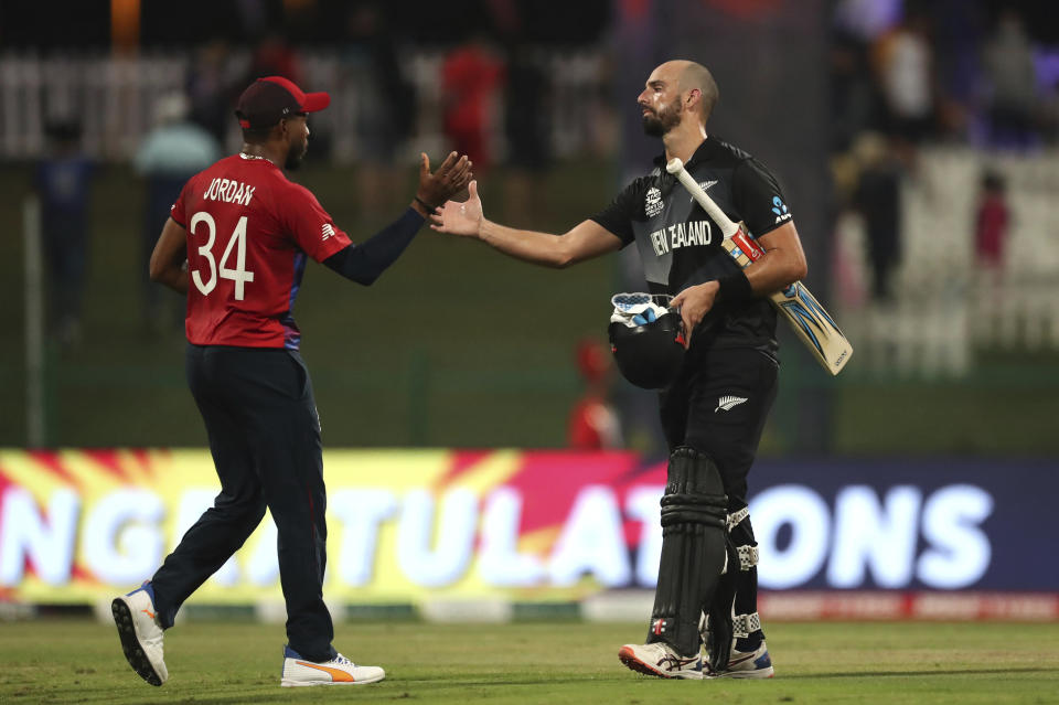 New Zealand's batsman Daryl Mitchell, right, shakes a hand with England's Chris Jordan at end of the Cricket Twenty20 World Cup semi-final match between England and New Zealand in Abu Dhabi, UAE, Wednesday, Nov. 10, 2021. New Zealand beat England by 5 wickets with 6 balls remaining. (AP Photo/Kamran Jebreili)