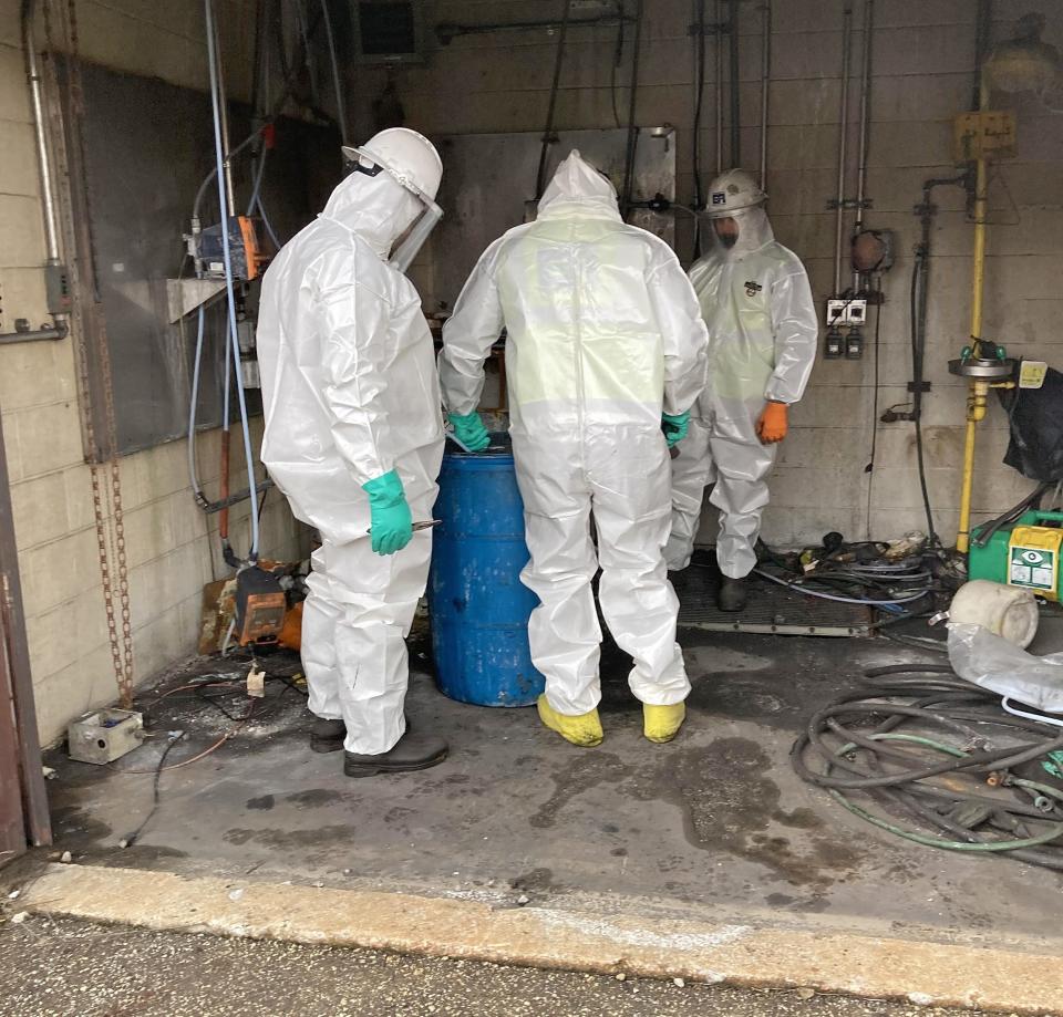 Workers contracted by the Environmental Protection Agency prepare a drum for off-site disposal on Jan. 5, 2021, as part of the clean-up operations at the former Erie Coke Corp.