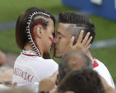 <p>Robert Lewandowski is comforted by his wife after the Group H loss </p>