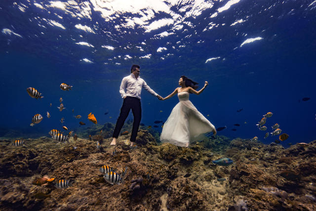 Bride and groom pose for underwater wedding shoot