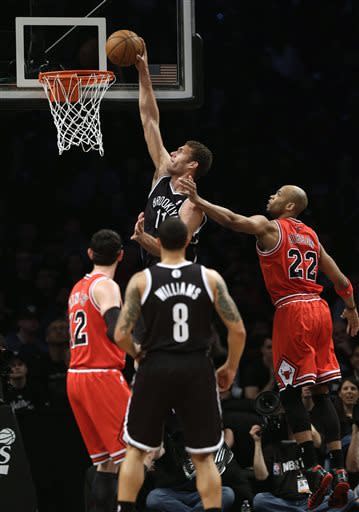 Brooklyn Nets' Brook Lopez, top, dunks against the Chicago Bulls during the first quarter of Game 1 of a first-round series of the NBA basketball playoffs, Saturday, April 20, 2013, in New York. (AP Photo/Seth Wenig)