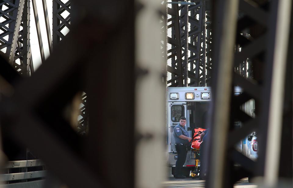 Emergency personnel removes the body of Brooklyn, Ill., police officer Brian Pierce Jr. from the Illinois side of the McKinley Bridge, Wednesday, Aug. 4, 2021. Pierce died early Wednesday while trying to stop a car fleeing police from crossing into Missouri, authorities said. (Robert Cohen/St. Louis Post-Dispatch via AP)