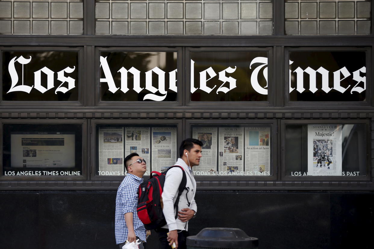 People walk past the LA Times building in Los Angeles. (Photo: Lucy Nicholson/Reuters)