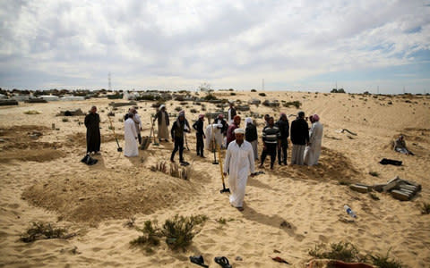 People bury victims of the of the Egypt Sinai mosque bombing - Credit: Photo by Stringer/Anadolu Agency/Getty Images