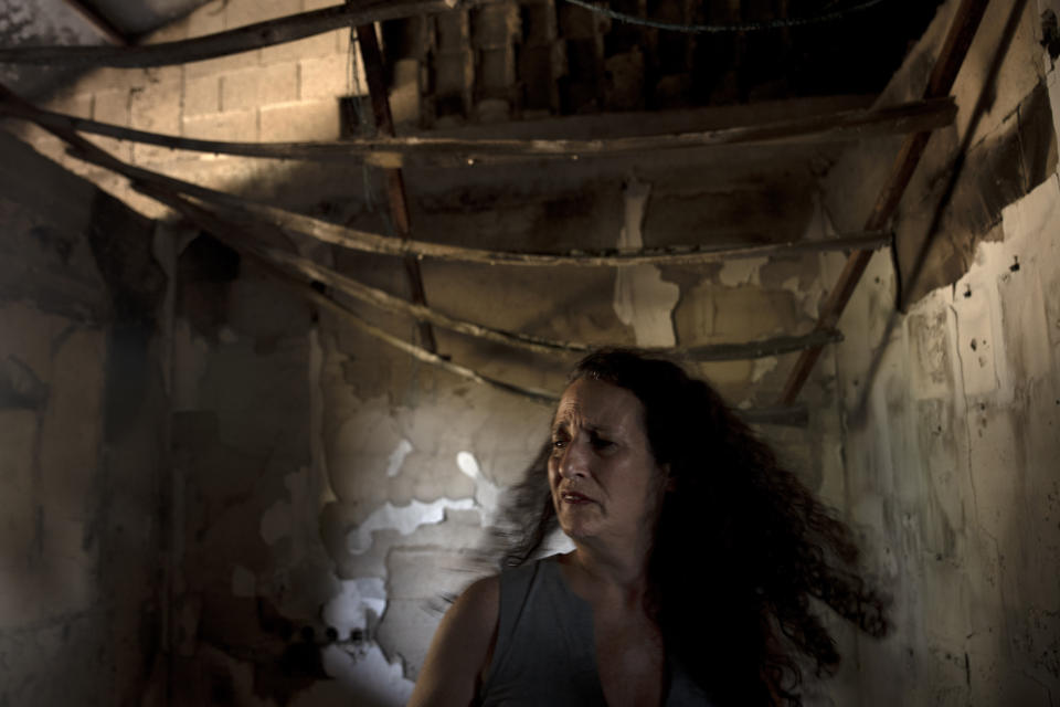 FILE - Hadas Kalderon is overcome by emotion in the ruins of her mother's home in Kibbutz Nir Oz, Israel, on Oct. 30, 2023. The kibbutz was overrun on Oct. 7 by Hamas militants, who killed or captured a quarter of its community, including Kalderon's mother, Carmela Dan, and 12-year-old niece, Noya. Kalderon's children, Erez, 12 and Sahar, 16, have been freed; the children's father, Ofer, is still in Gaza. (AP Photo/Maya Alleruzzo)