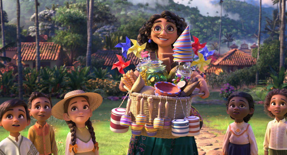En esta imagen difundida por Disney, el personaje de Mirabel, en el centro, cuya voz en inglés hace Stephanie Beatriz, en una escena de la película animada "Encanto". (Disney vía AP)