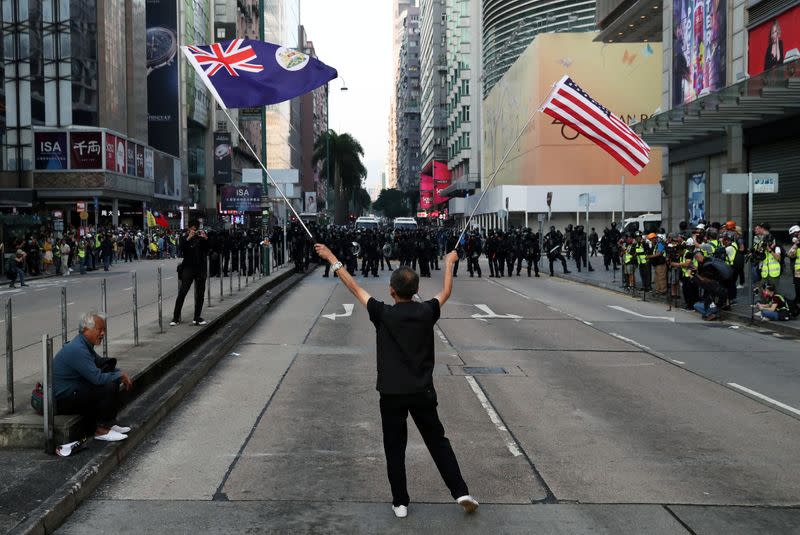 A protester waves a U.S. and a colonial Hong Kong flags during the "Lest We Forget" rally in Hong Kong