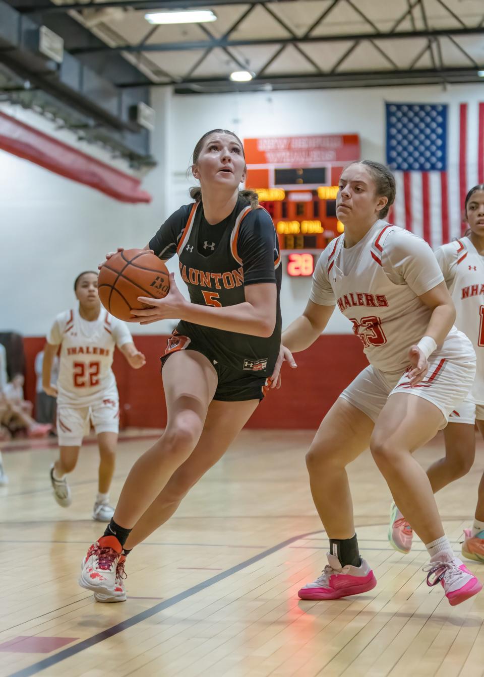 Taunton's Taryn Campbell drives to the basket while New Bedford's Zaria Anderson defends on the play.