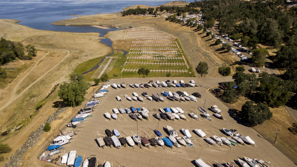 In an aerial view, boat docks sitting on dry land at the Browns Ravine Cove area of drought-stricken Folsom Lake, currently at 37% of the normal capacity, in Folsom, Calif., Saturday, May 22, 2021. California Gov. Gavin Newsom declared a drought emergency for most of the state. (AP Photo/Josh Edelson)