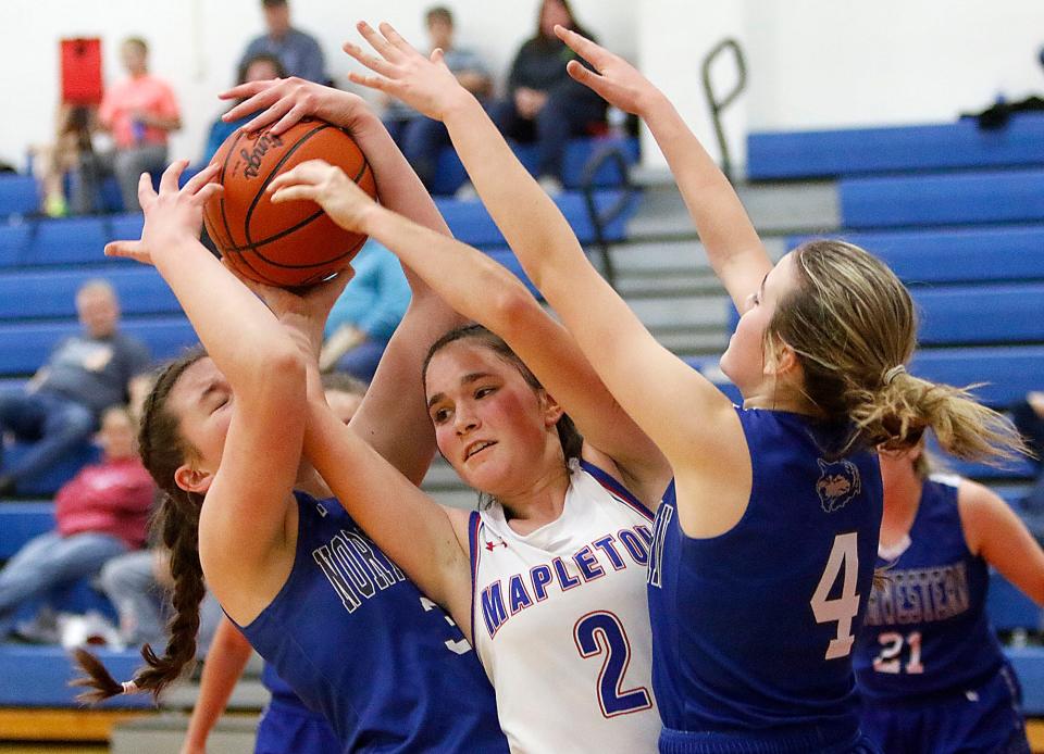 Mapleton High School's Holly Earl (2) battles for control of a rebound with Northwestern High School's Lillian Wakefield (32) and Caydance Scale (4) during high school girls basketball action on Tuesday, Jan. 18, 2022 at Mapleton High School. TOM E. PUSKAR/TIMES-GAZETTE.COM