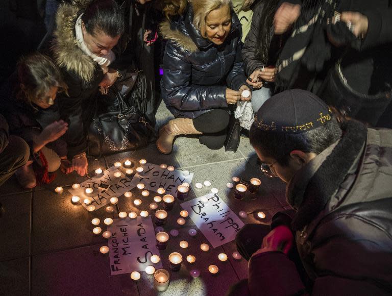 French-Israeli dual nationals light candles around the names of French Jews killed in an attack on a supermarket in Paris during a remembrance ceremony in the coastal city of Netanya, Israel, on January 11, 2015