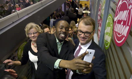 Chairman Juha Sipila (R) of the Centre Party has a selfie taken at the party's parliamentary elections reception in Helsinki April 19, 2015, after the results of the votes. REUTERS/Markku Ulander/Lehtikuva