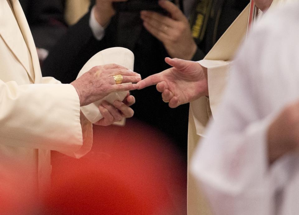 FILE - The hand of Pope Francis, right, salutes Pope Emeritus Benedict XVI, at the end of a consistory inside the St. Peter's Basilica at the Vatican, on Feb. 22, 2014. Pope Benedict XVI’s 2013 resignation sparked calls for rules and regulations for future retired popes to avoid the kind of confusion that ensued. Benedict, the German theologian who will be remembered as the first pope in 600 years to resign, has died, the Vatican announced Saturday Dec. 31, 2022. He was 95. (AP Photo/Alessandra Tarantino, File)