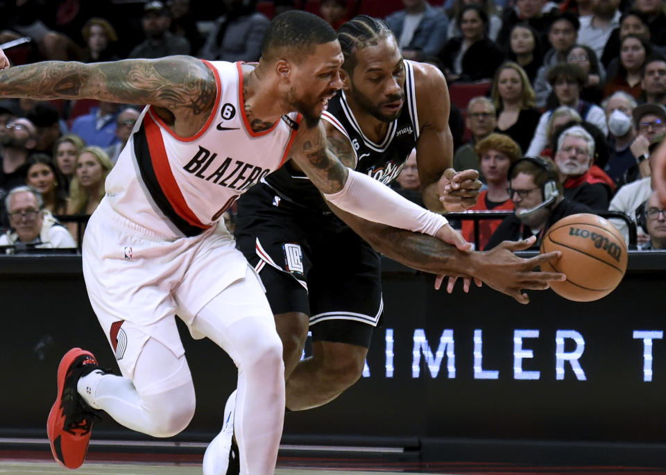 Los Angeles Clippers forward Kawhi Leonard, right, reaches in on Portland Trail Blazers guard Damian Lillard, left, during the first half of an NBA basketball game in Portland, Ore., Sunday, March 19, 2023. (AP Photo/Steve Dykes)